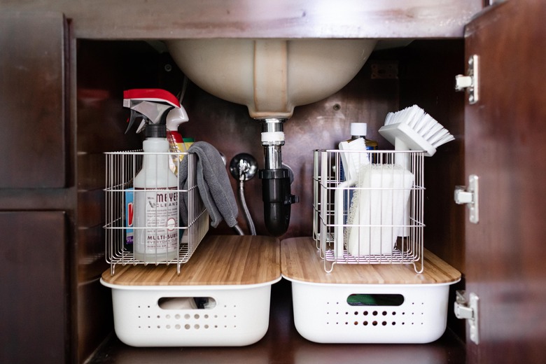 photo of under the sink storage area with cleaning supplies in baskets