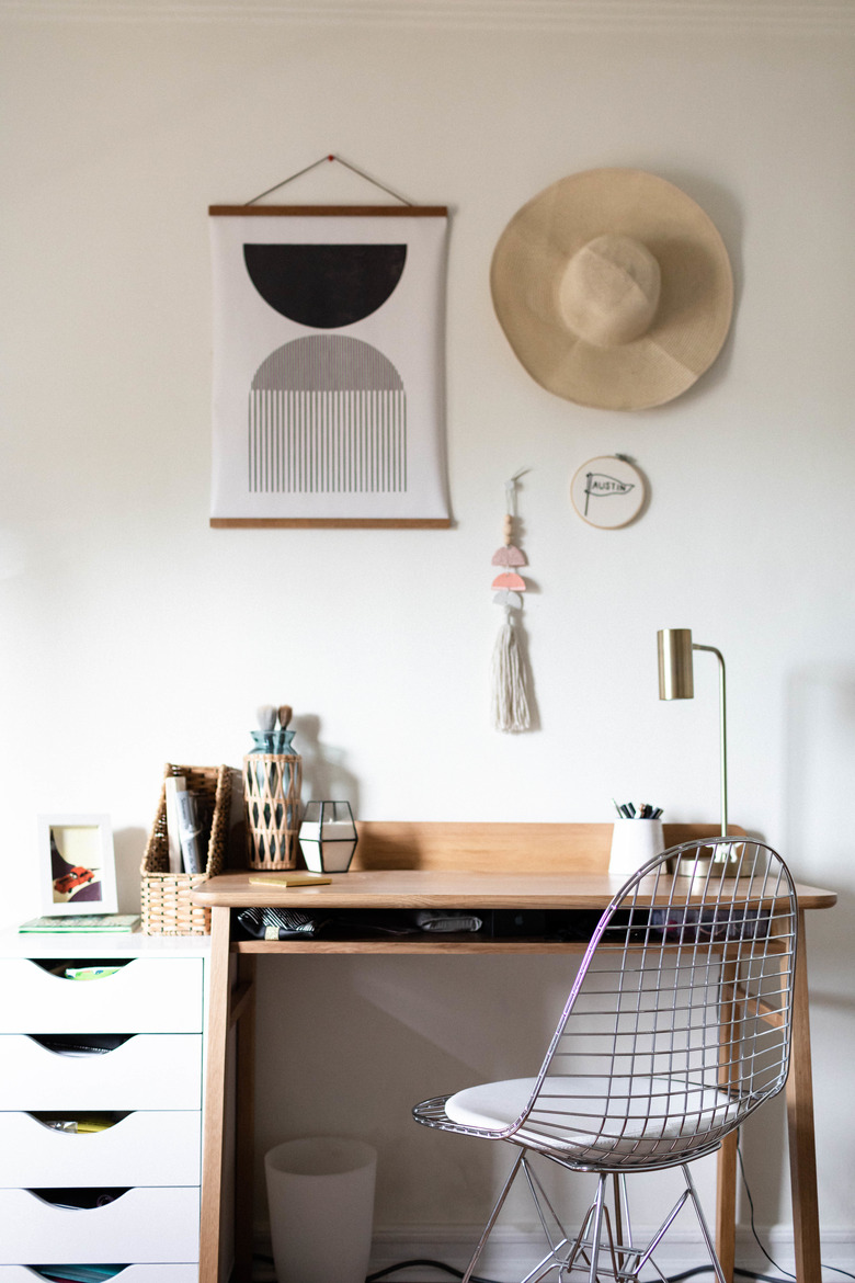 Small home office space with wood writing desk and geometric wall print