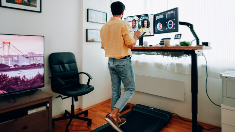 Man at standing desk home office talking on business video call