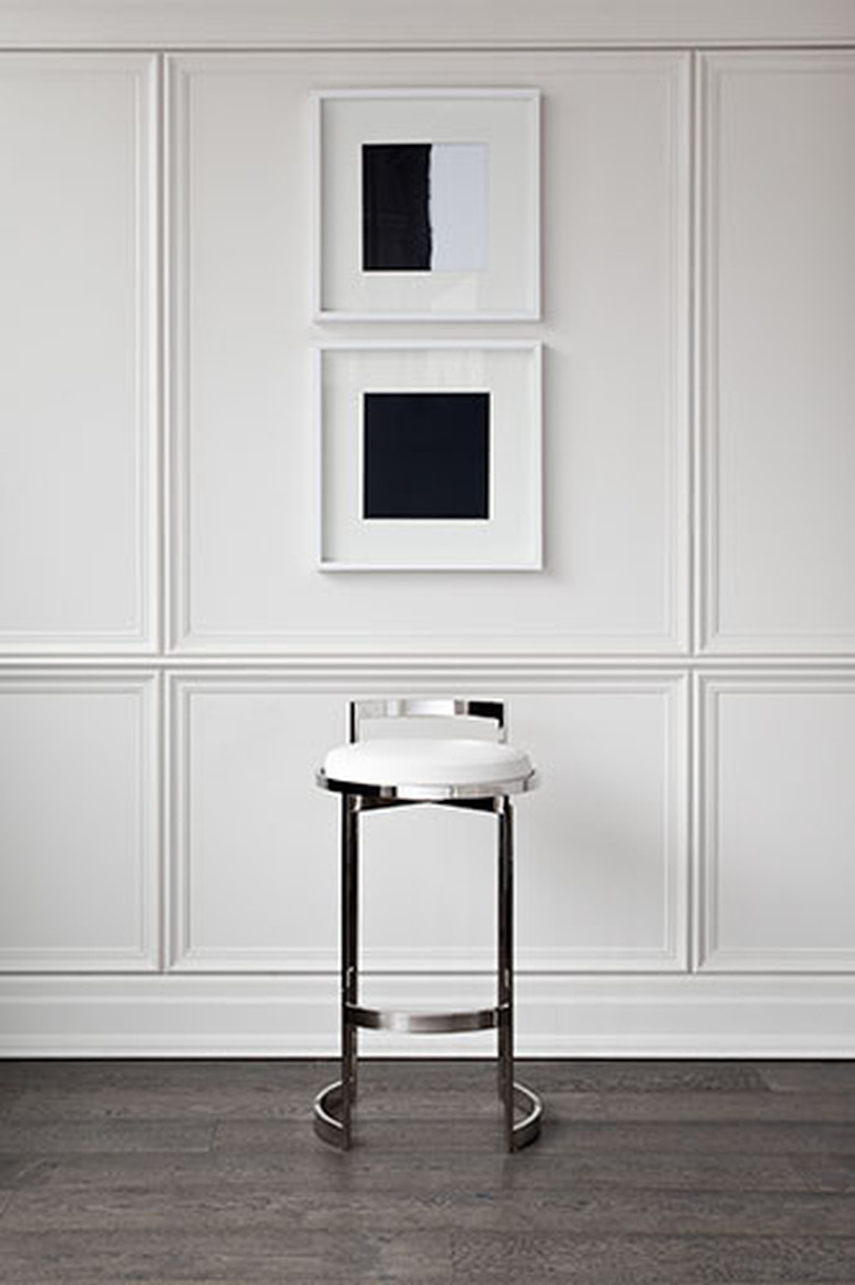 white wainscoted wall with silver barstool pictured