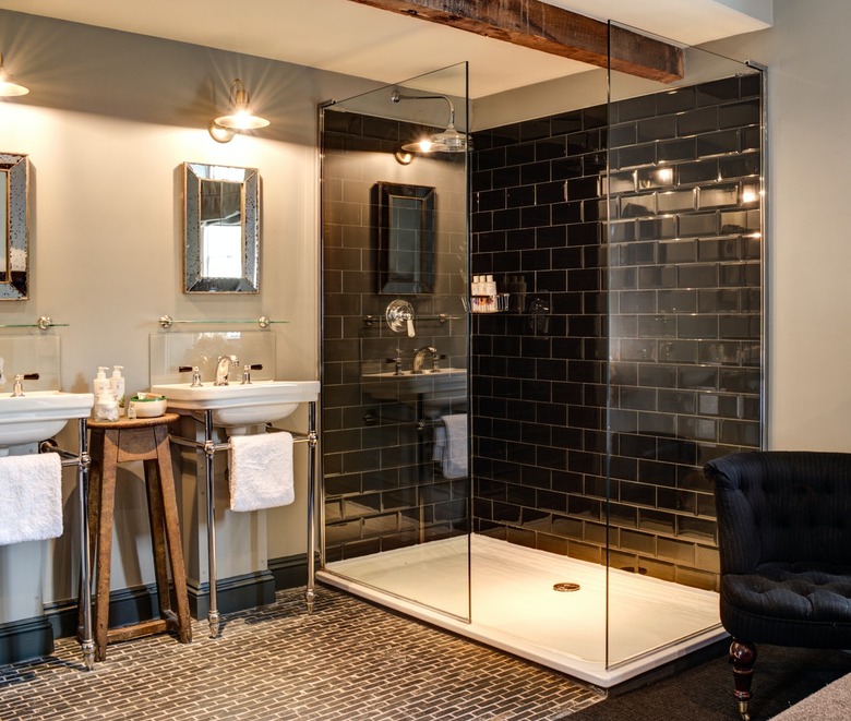 glossy black rustic shower tile in bathroom with wood beams and penny floor tile