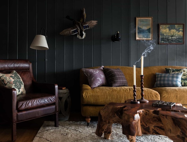 black basement wall ideas in cabin with leather chair and tree stump coffee table