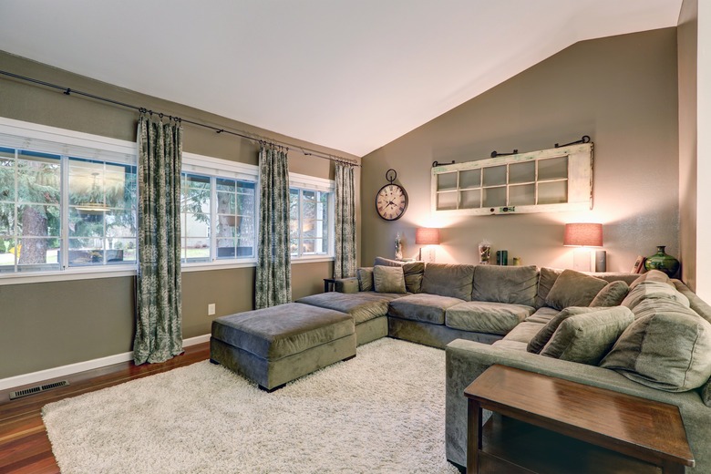 Vaulted ceiling family room with taupe walls and taupe sofa.