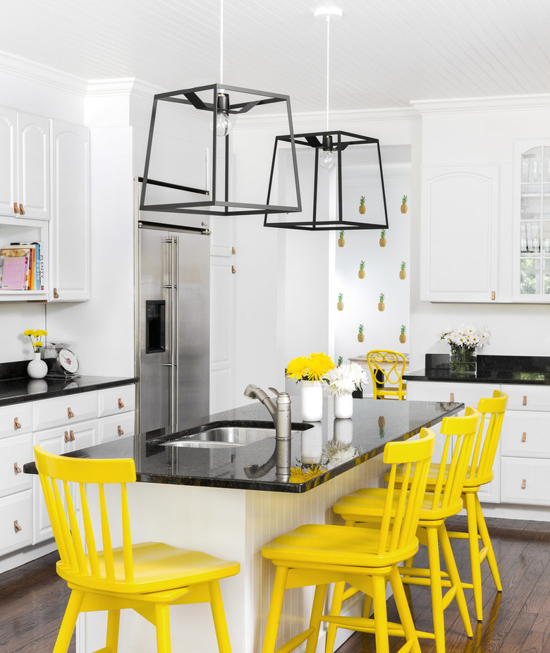 beadboard kitchen island with black granite countertop and yellow counter stools