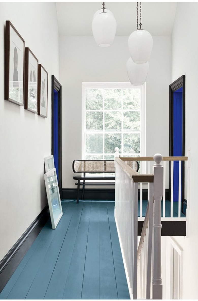 white hallway with green floors and black doorways