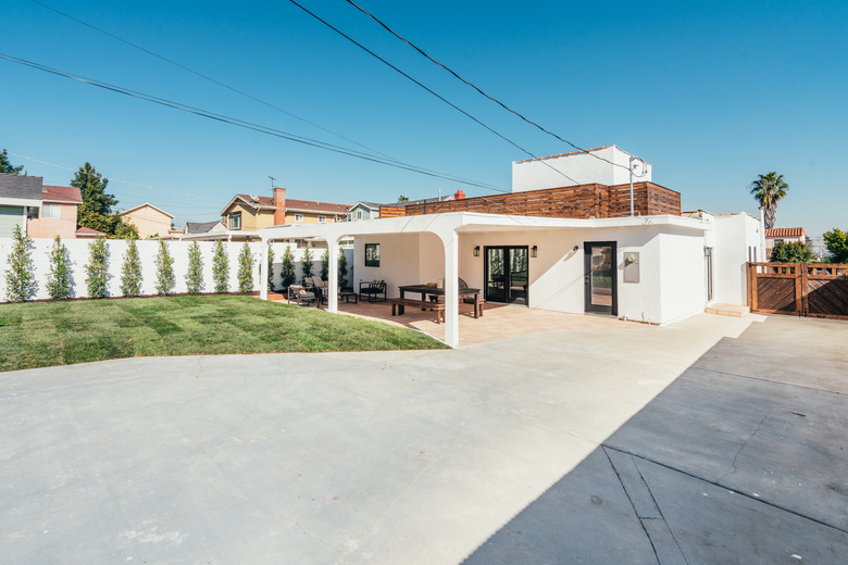 A mediterranean style home with a concrete driveway and a minimalist yard