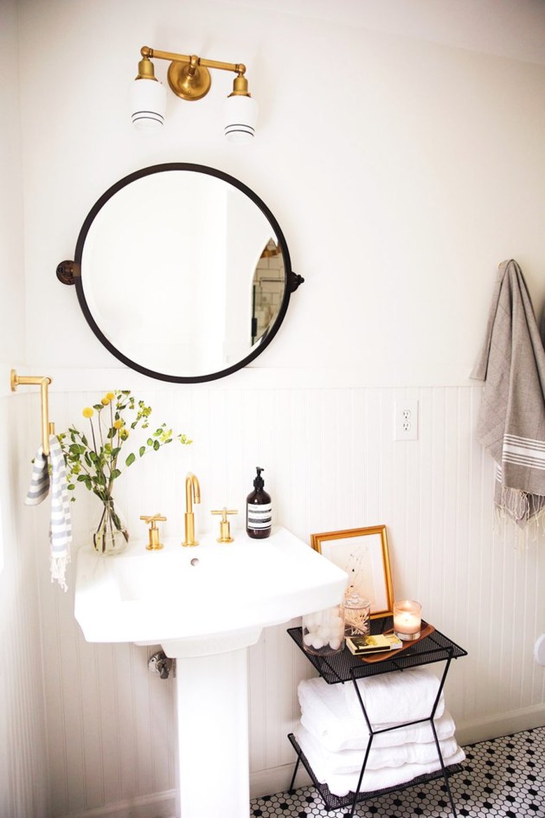 Pedestal Sink Storage Ideas in Bathroom with white pedestal sink, round mirror, sconce light, black side table