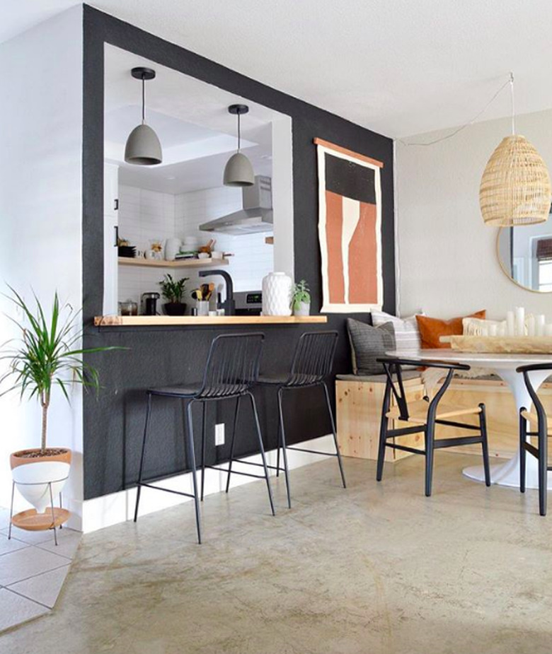 Minimal bohemian dining room with midcentury furniture and black accent wall