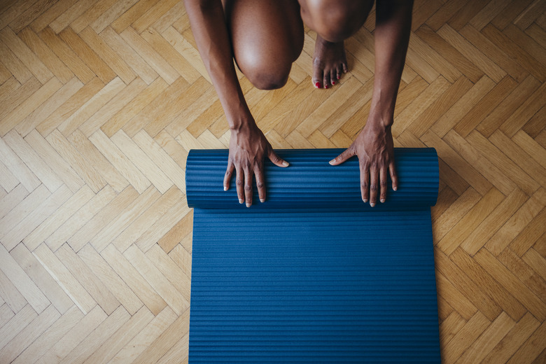 An Anonymous Fitness Woman Folding Blue Exercise Mat