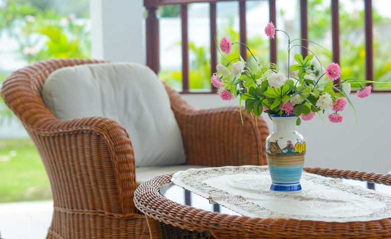 Weave chair with white pillow and flower vase with nature background