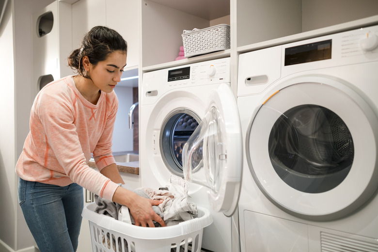 Unloading clean laundry from washing machine.