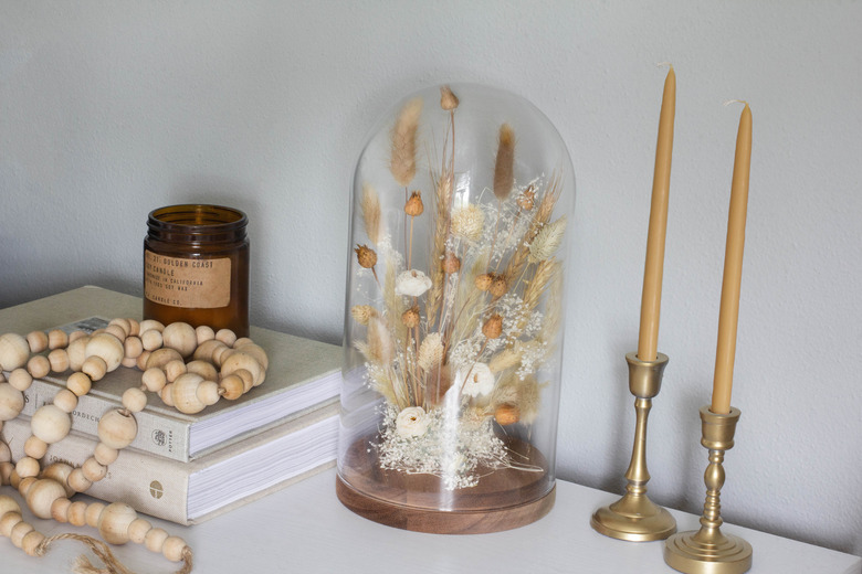 Dried floral cloche on mantel with candles