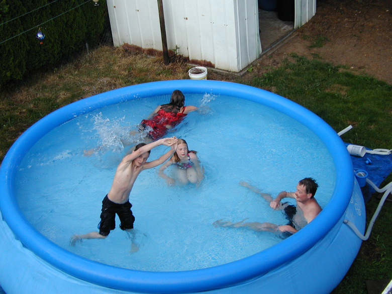 Kids playing in a soft-side above-ground swimming pool.