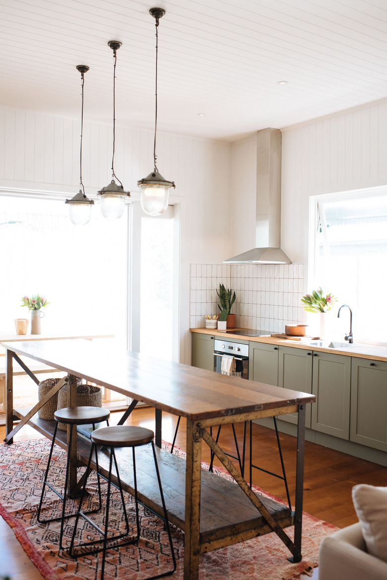 olive green kitchen color idea with wood countertops and pendant lights