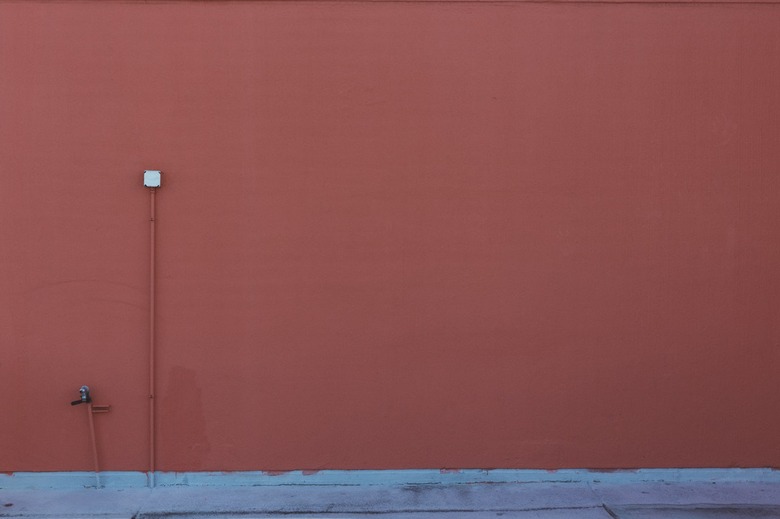 Outdoor pipes blend with the wall.