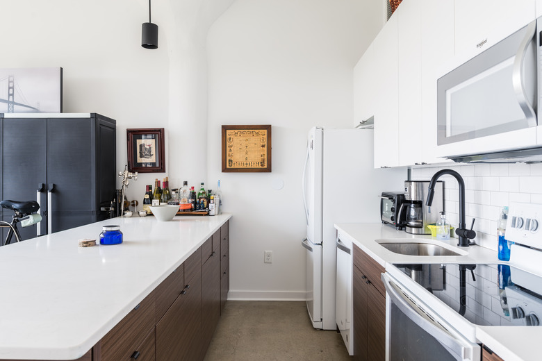 modern kitchen with white countertops and dark wood kitchen cabinets