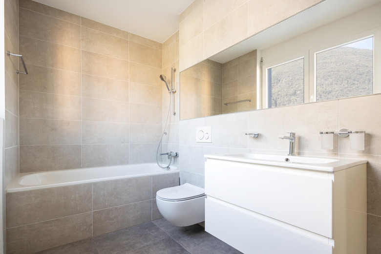 Modern minimal bathroom with large tile bathtub