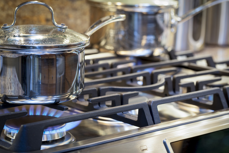 Pot on stove with gas burner and flame