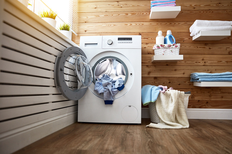 Interior of real laundry room with washing machine at window at home