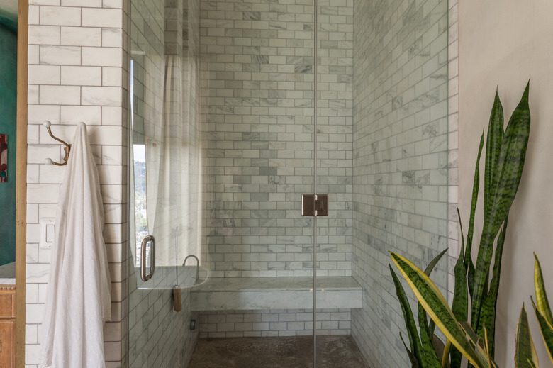 shower with light subway tile wall and bench