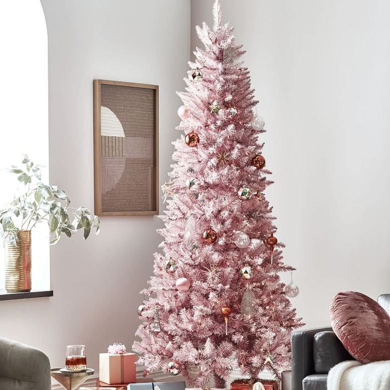 Christmas Tree Themes with Pink artificial Christmas tree, art on wall, purple throw cushion.