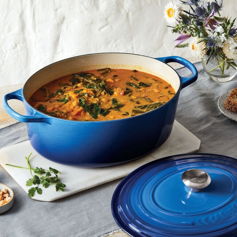 blue dutch oven with orange stew cooking