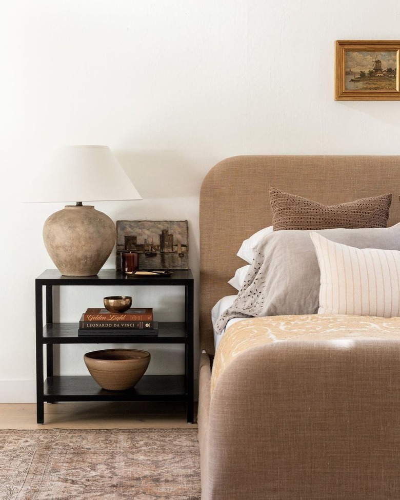 bedroom with brown upholstered bed and tan beadspread