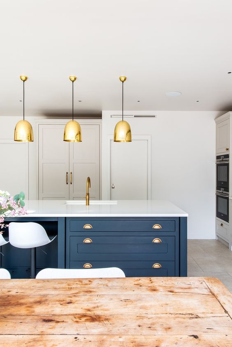 blue kitchen island with brass accents and white countertop