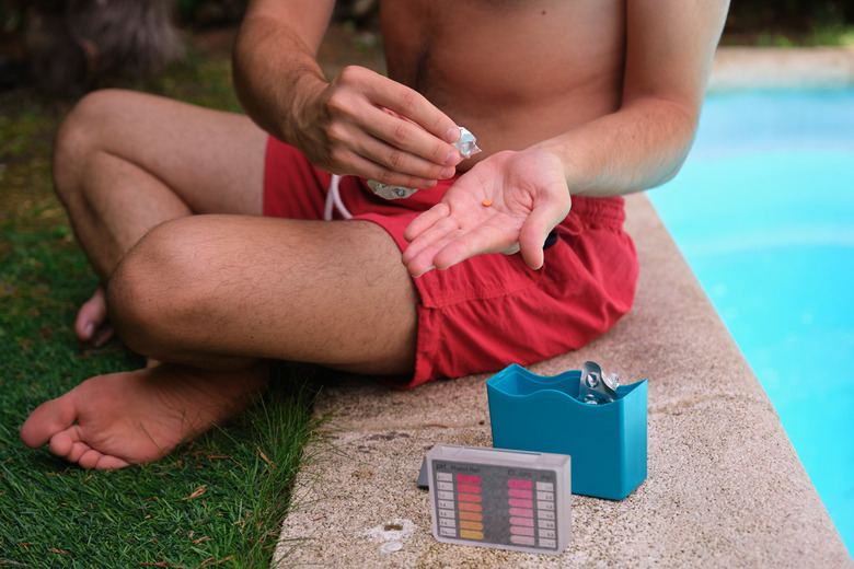 Using a pH and cl kit to test the pool water quality.