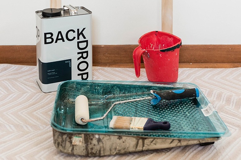 Paint tray, paint brush, paint roller, container of paint, and a paint bucket