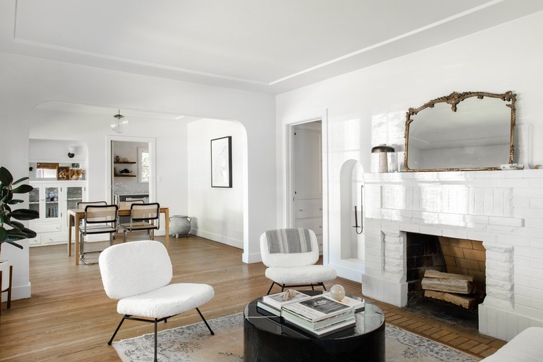 Minimalist and contemporary living room with white and black furniture and neutral, wood accents.