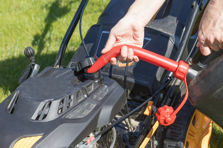 Pouring gasoline into lawn mower