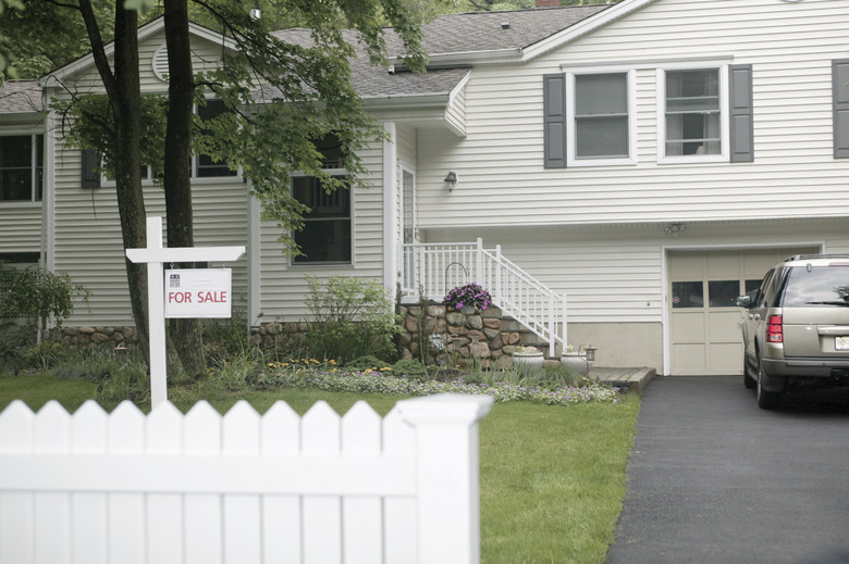 House with for sale sign in front yard