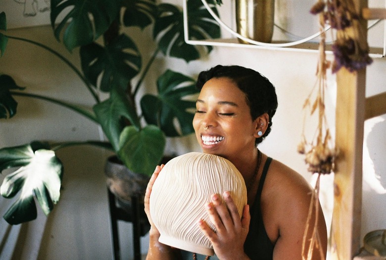 Tasha Reneé holding one of their ceramic pieces