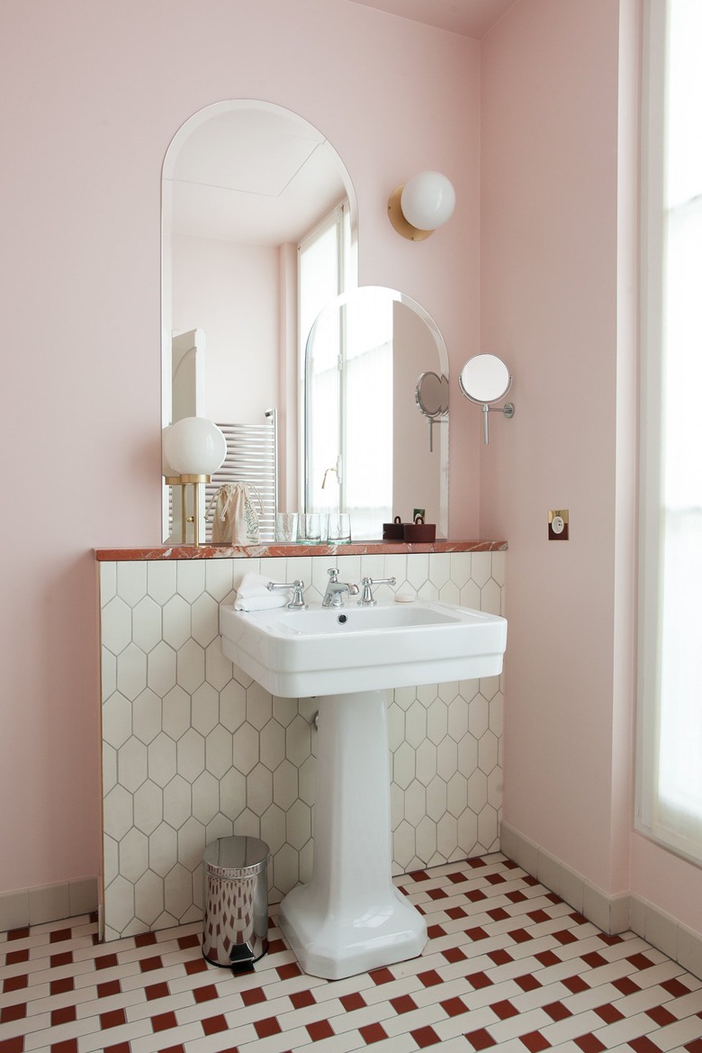 pedestal bathroom sink with pink walls and patterned floor tile