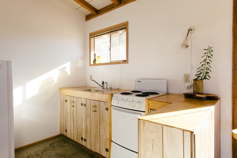 a kitchen with natural wood cabinets and an electric stove