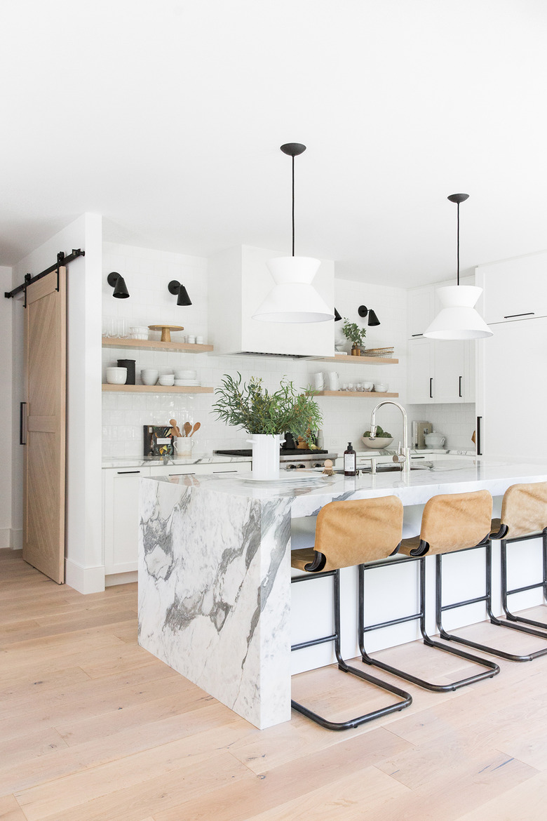 kitchen bar idea with minimal kitchen with marble countertops and leather cantilever bar stools.