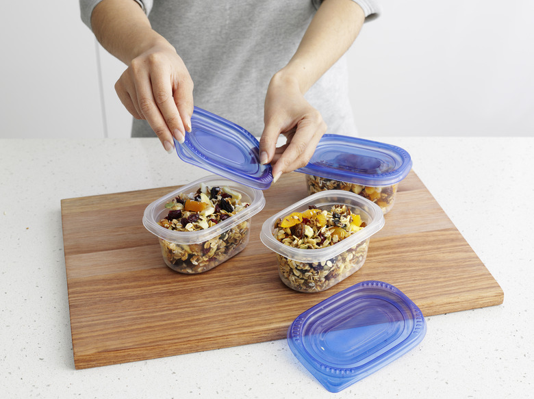 Woman packing granola in tupperware