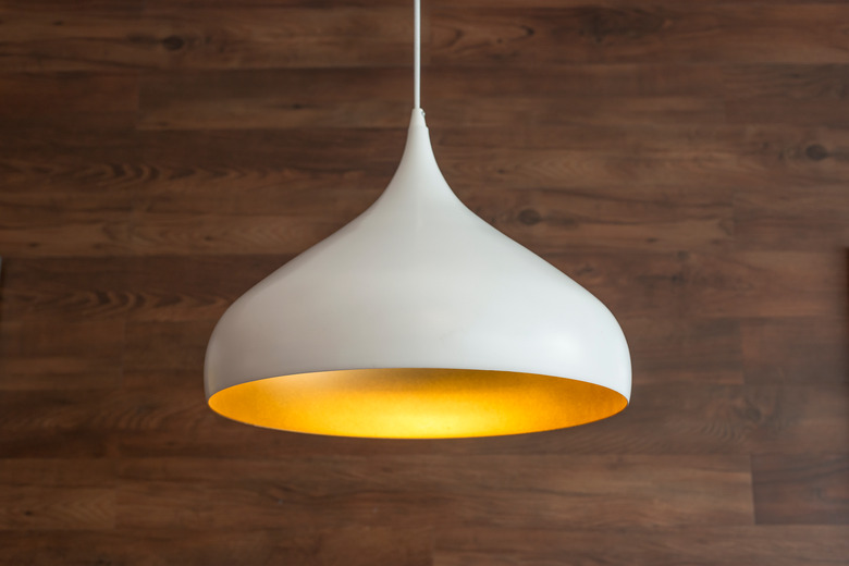 Close-Up Of Pendant Light Hanging Against Wooden Wall