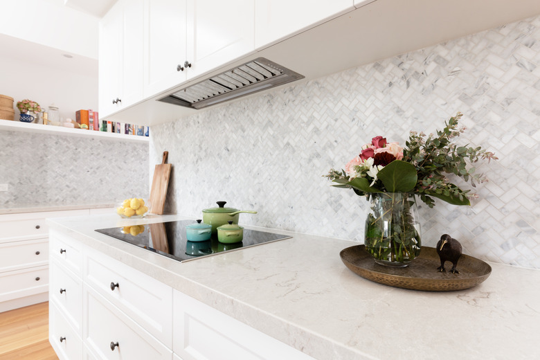 Rear kitchen bench styled with cut flowers and colorful saucepans