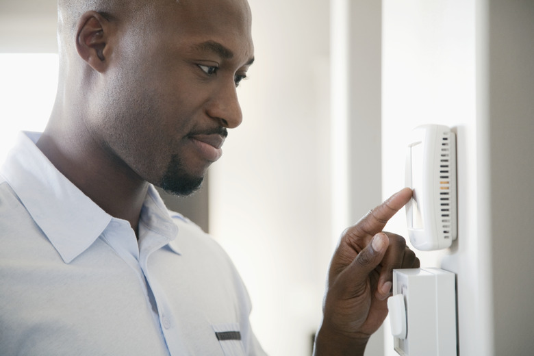 Man adjusting thermostat