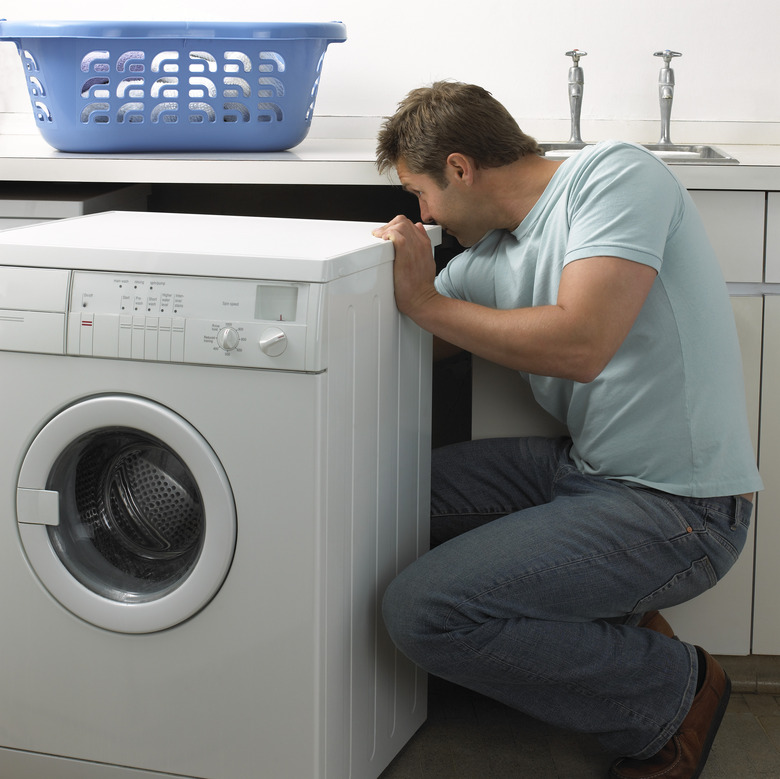 Man in a Kitchen Repairing a Washing Machine