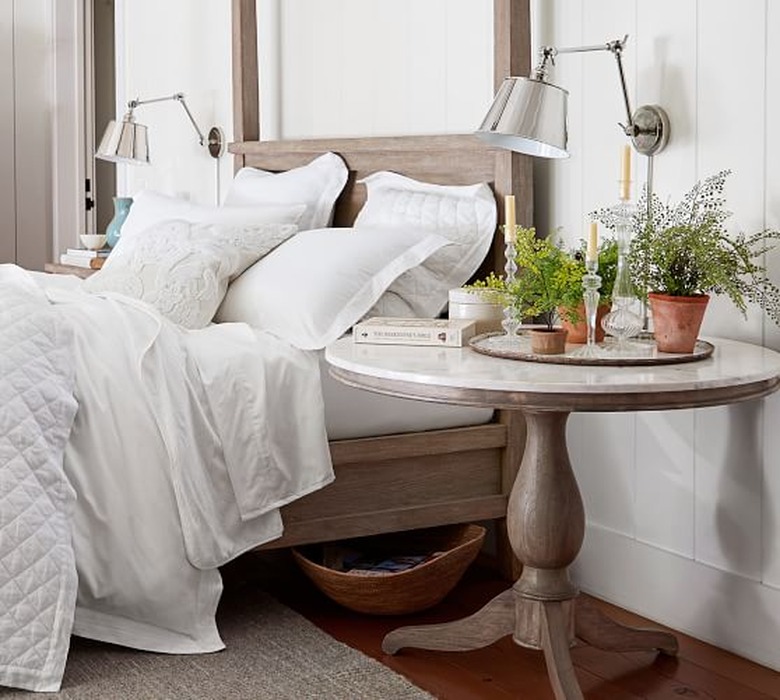 Pottery Barn farmhouse furniture with round bedside table and wood bed frame