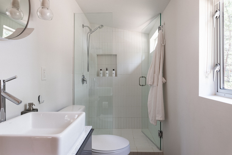 Modern white bathroom with frameless shower door.