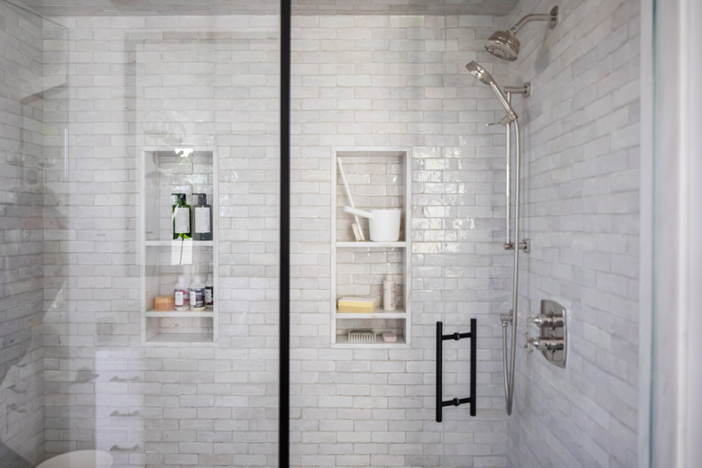 shower with light grey subway tile walls and glass door