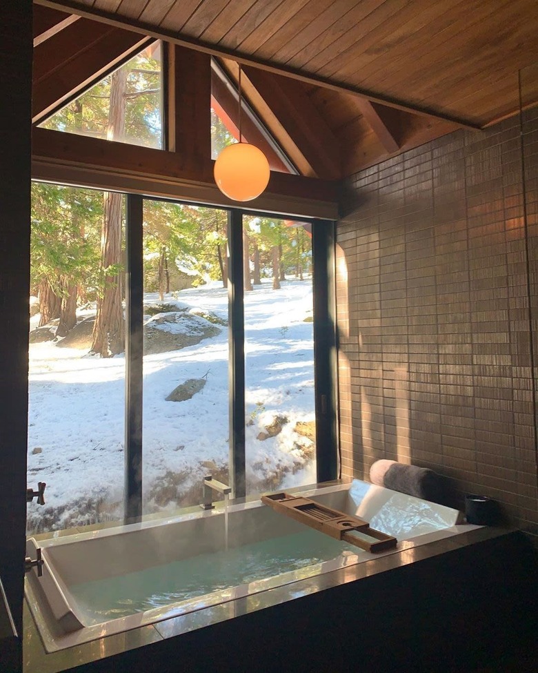 bath tub with view of trees and snowy scene