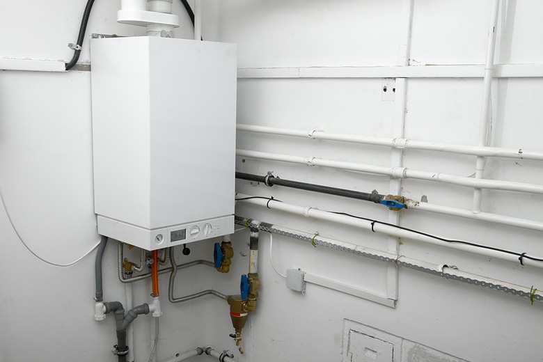 Corner of a room with white boiler and connectors