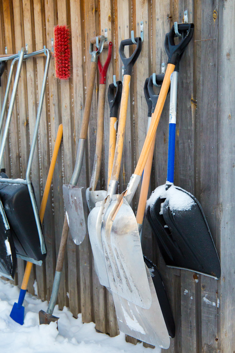 Snow shovels hanging against barn.