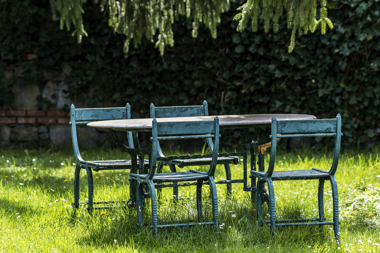 Old iron furniture in garden at springtime