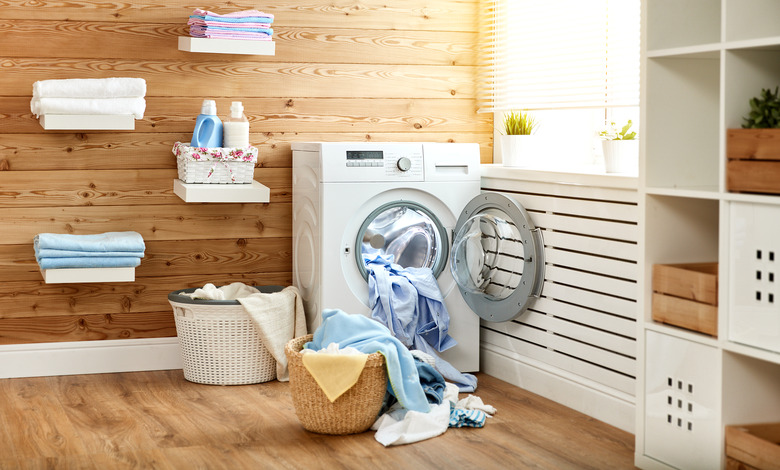 Interior of real laundry room with washing machine at window at home